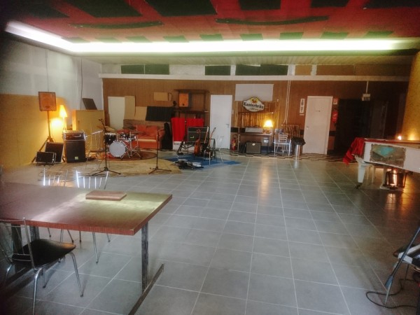 Salle de concert avec une grande surface vide et un espace avec des instruments