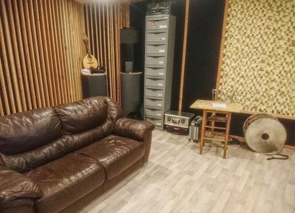 Espace studio contenant un canapé et des instruments